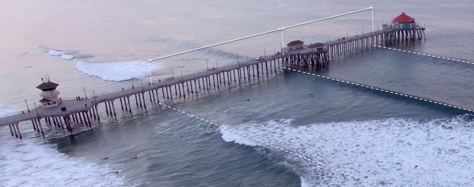 In a moment in time, a set of moving waves hits a pier at different locations —transforming time in space.